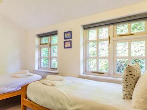 twee bedden in een kamer met twee ramen bij 3 Rose Cottages in St. Agnes 