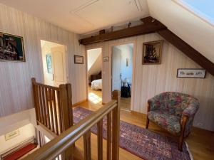 an attic room with a staircase and a chair at Villa 5 pièces avec jardin, à 400m de la plage et 600m des commerces, wifi et barbecue inclus - FR-1-361-20 in Jullouville-les-Pins