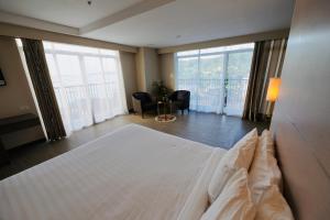 a bedroom with a large bed and a large window at S Resort El Nido in El Nido