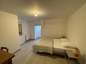 ein Schlafzimmer mit einem Bett und einem Tisch darin in der Unterkunft Appartement confortable proche des Thermes avec lave-vaisselle et options de location de linge - FR-1-541-9 in La Roche-Posay