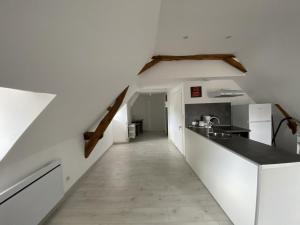 eine Küche mit weißen Wänden und einem langen Flur in der Unterkunft Appartement confortable proche des Thermes avec lave-vaisselle et options de location de linge - FR-1-541-9 in La Roche-Posay