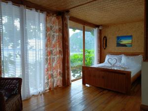 a bedroom with a bed and a large window at Hut Sunset Island View in El Nido