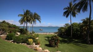 a view of the ocean from a resort with palm trees at Whitsunday Sands Resort in Bowen