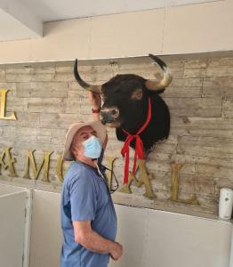un hombre con una máscara delante de una cabeza de toro en El Gamonal - Paracas, en Paracas