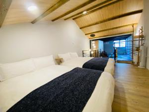 two beds in a room with wooden ceilings at 倚鳳閣 in Tainan