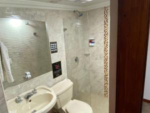 ein Bad mit einer Dusche, einem WC und einem Waschbecken in der Unterkunft Hotel L&L Mansión in Bogotá