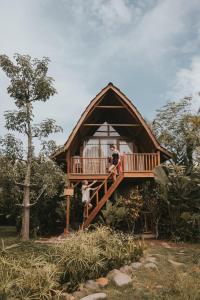 two people standing on the deck of a house at Kusfarm Bali in Selemadeg