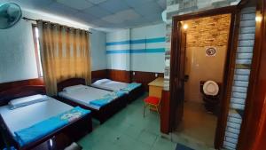 芹苴的住宿－譚泰多酒店，小房间设有两张床和一张桌子