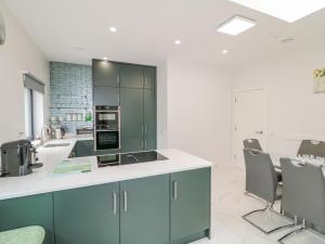 a kitchen with green cabinets and a white counter top at Wee Andy's in Buncrana