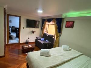 a bedroom with a bed and a living room with a couch at Hotel L&L Mansión in Bogotá
