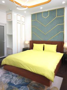 a bedroom with a large bed with a yellow blanket at Free Style Hotel Dalat in Da Lat
