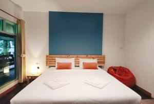 sypialnia z dużym białym łóżkiem z pomarańczowymi poduszkami w obiekcie Nua Tone Resort Bang Tao & Cafe w mieście Bang Tao Beach