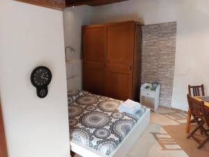 a bedroom with a bed and a clock on the wall at Casa Vittoria in Calcata