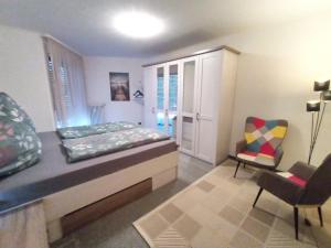 a bedroom with a large bed and a chair at BodenSEE Apartment Überlingen Strandweg in Überlingen