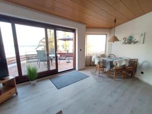ein Wohnzimmer mit einem Tisch und Stühlen mit Aussicht in der Unterkunft BodenSEE Apartment Überlingen Strandweg in Überlingen