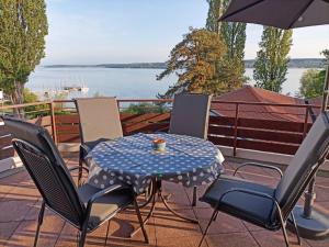 una mesa con sillas y una taza de café en el patio en BodenSEE Apartment Überlingen Strandweg, en Überlingen