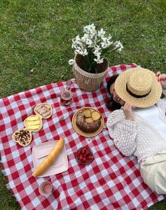 Eine Frau, die mit Essen auf einer Picknickdecke liegt. in der Unterkunft Bude Mestia cottages in Mestia