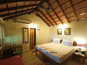 a hotel room with a bed, chair, and table at OmBodhi Retreat in Kumta