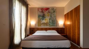 una camera da letto con un letto e un quadro sul muro di HOTEL QUERINI Business Hotel Sandrigo a Sandrigo