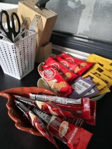 a table with a bowl of candy and a box of scissors at Jungle Loft for 6-7pax near IKEA, Kidzania and 1U in Petaling Jaya