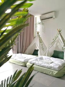 two beds in a room with a plant at Jungle Loft for 6-7pax near IKEA, Kidzania and 1U in Petaling Jaya