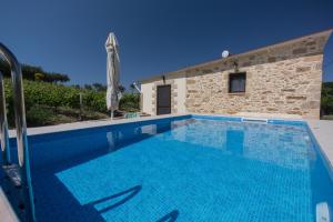 una piscina di fronte a una villa di Villa Margarita's farm, private pool a Maláthiros