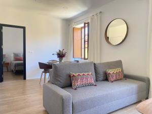 uma sala de estar com um sofá cinzento e um espelho em Hispalis Jardines de Murillo em Sevilha