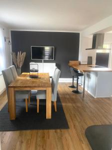 a dining room with a wooden table and chairs at stylisches Ferienhäuschen in Güstrow