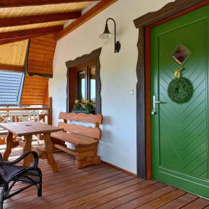 zielone drzwi na ganku ze stołem i ławką w obiekcie Domki w Tajemniczej Krainie w Wetlinie