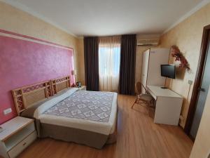 Habitación de hotel con cama y nevera en Hotel Le Pageot en Aosta