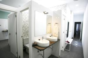 a white bathroom with two sinks and a mirror at Estuhome in Madrid