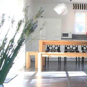 a dining room with a table and a bench at Weißes Traumhaus in Glowe