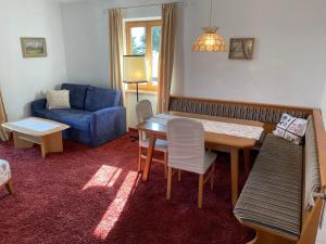 ein Wohnzimmer mit einem Tisch und einem blauen Sofa in der Unterkunft Haus Riedl in Seefeld in Tirol