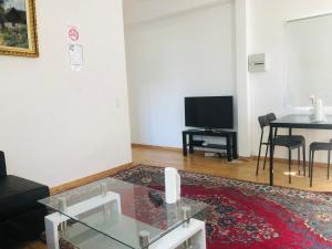 a living room with a glass coffee table and a television at A1 Stay Apartments in Copenhagen