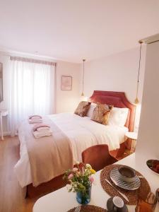 a bedroom with a large white bed with a table at Sole e Luna Studio · Corfu Old Town in Corfu