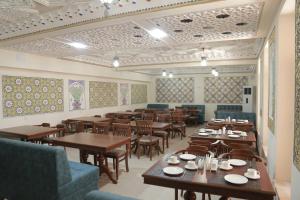 een eetkamer met houten tafels en stoelen bij AL-MALIK Boutique Hotel in Bukhara