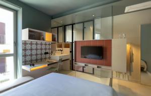 1 dormitorio con cama, lavabo y TV en Le stanze di Caterina, en Cesenatico