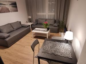 a living room with a table and a couch at MustSEA Gdańsk Apartments with underground parking in Gdańsk