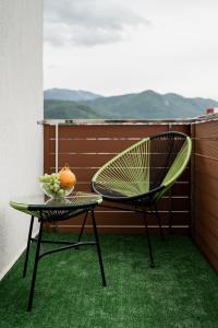 een stoel en een tafel op een balkon bij Skylark - Miami Studio with Terrace & Mountain View in Braşov