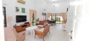 Kampong Alor GajahにあるA'Famosa Private Pool Villaのソファとテーブルと椅子のあるリビングルーム