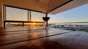 a glass of wine sitting on top of a wooden table at The Starling in St Helena Bay +7 photos