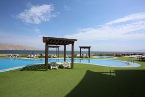 a rendering of a swimming pool with two chairs in the grass at Atana Khasab Hotel in Khasab