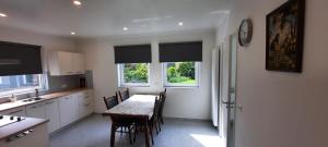 a kitchen with a table and chairs and two windows at Vakantiehuis Mastdreef in Breda +7 photos