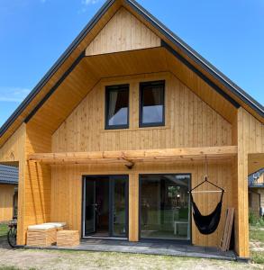 a wooden house with a large glass door at Domki Rózin in Zwierzyniec