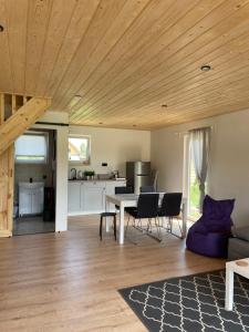 a kitchen and living room with a wooden ceiling at Domki Rózin in Zwierzyniec