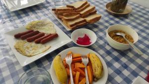 une table avec des assiettes de nourriture sur une table dans l'établissement 98 Home Lodge Dambulla, à Dambulla