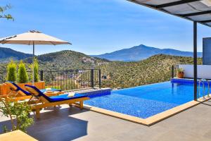 a villa with a swimming pool with mountains in the background at Villa Summery in Kalkan