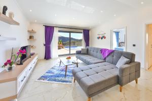 a living room with a couch and a tv at Villa Summery in Kalkan