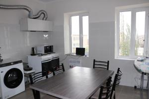 a kitchen with a wooden table and chairs in a room at Issyk - Kol Hotel in Balykchy