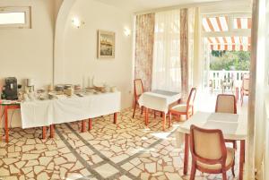 a dining room with two tables and chairs and a window at Villa Kipre in Cavtat